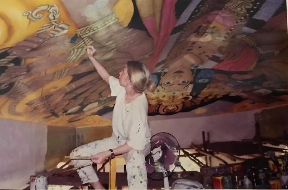 A performer onstage with a vibrant, colorful backdrop.