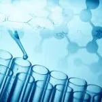 Scientific test tubes with a pipette in a lab setting.