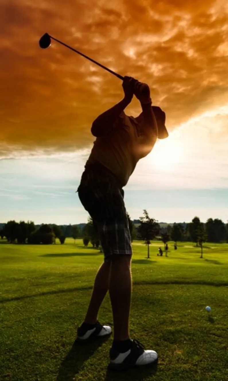 Golfer swinging club at sunset on a golf course. Golfer swinging club at sunset on a golf course.